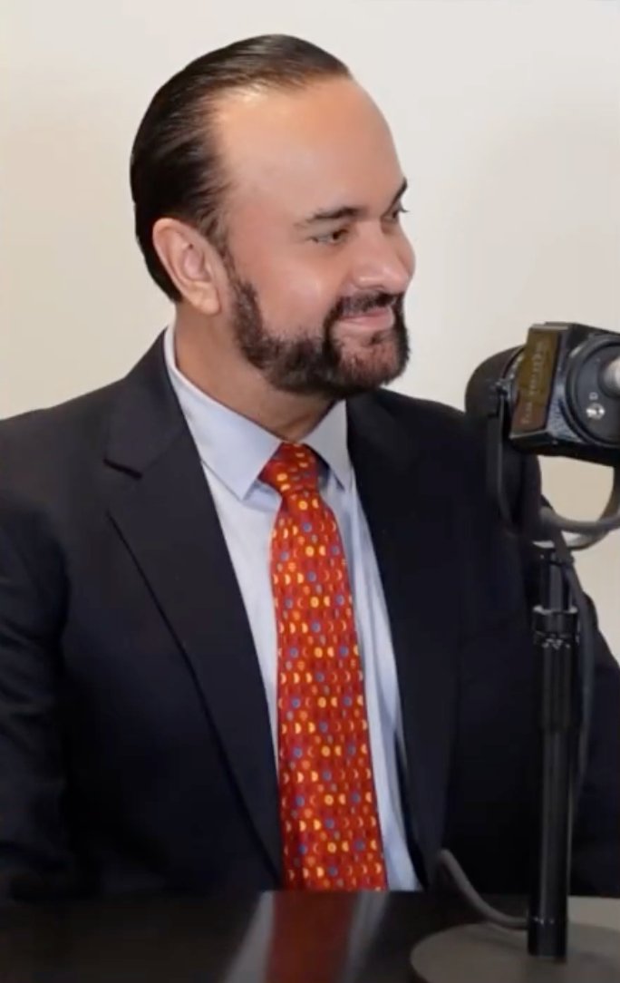 Cuauhtémoc Galaviz sonriendo frente a un micrófono.